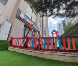 Bahçe kenarındaki renkli ahşap oyun ve tırmanma korkuluğu