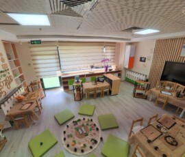Yeşil minderli, ahşap raflı geniş etkinlik ve oyun odası